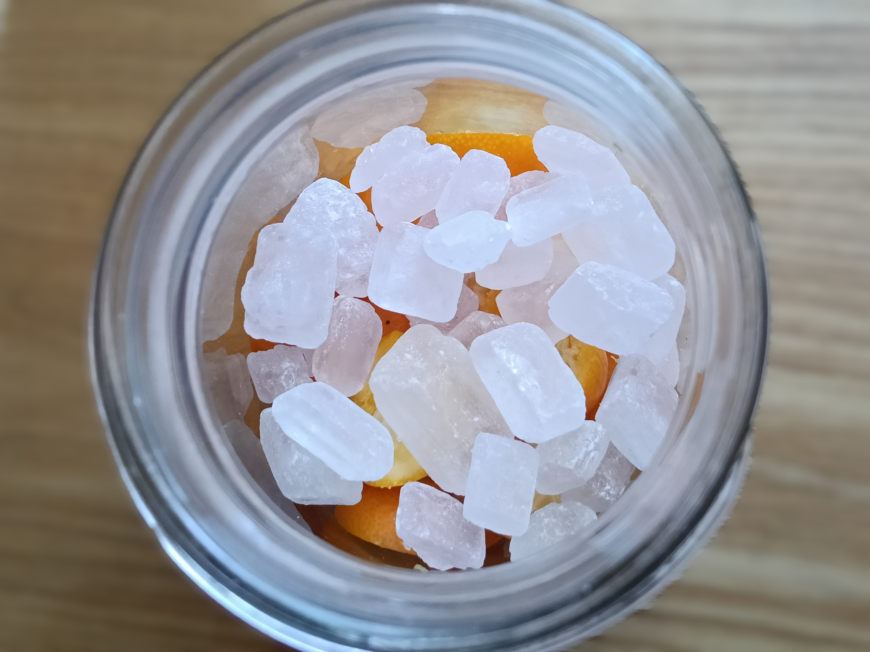 金柑と氷砂糖を瓶に詰めている画像